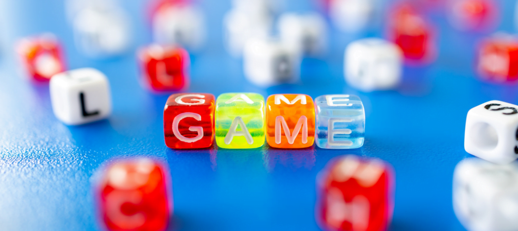 Picture of learning games, four cubes spelling the word game to illustrate a blog on experiential learning and business games